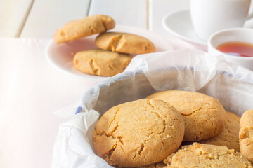 Close Up of Gingernuts in a Tin with Tea in the Background Horizontal
