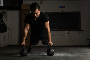Naklejka premium Athletic man doing push-ups in a gym