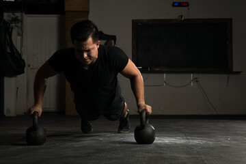 Doing kettlebell push-ups in a gym