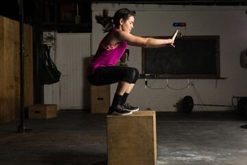 Athletic woman doing box jumps