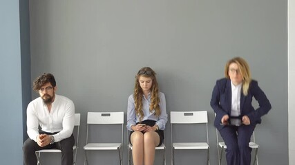 young people expect interviews sitting on chairs in an office building. the interview for the job. recruits are bored and enjoy the gadgets