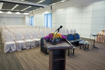 Microphone on podium of conference hall or seminar room background
