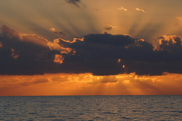 Sunsets from behind clouds off west coast of united states