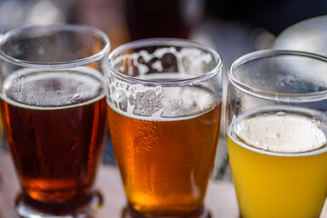 closeup of a beer flight sampler outside at microbrewery in summer sun