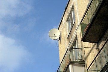 Satellite dish on the wall of the house.