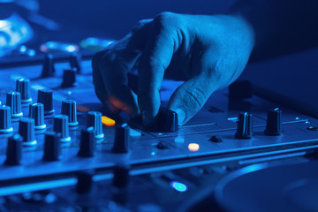 DJ mixing music with blue light