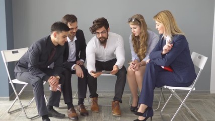 young businessman hipster holds a tablet PC. young entrepreneurs discuss start-up in an empty office