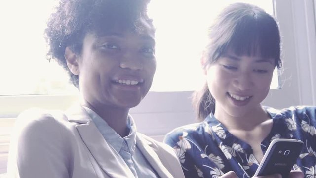 Women looking at smart phone together