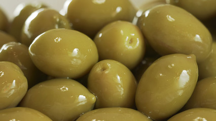 Large shiny green olives macro background