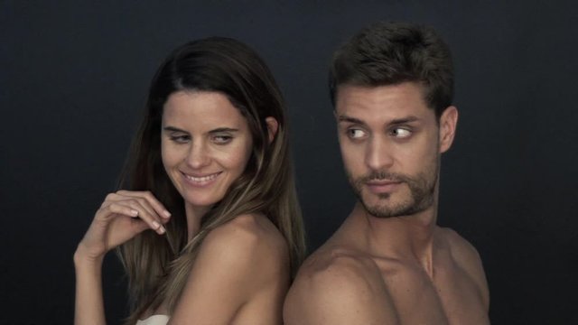 Couple leaning back to back, smiling over shoulders at each other
