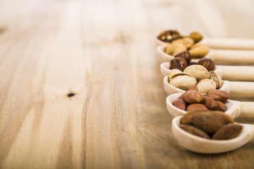 Nuts in a wooden spoons on a  wooden table