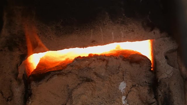 4K close-up shot that A flame and smoke is coming out of a porcelain kiln brick.