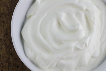 Fototapeta na wymiar Bowl of Greek swirled natural yoghurt close up