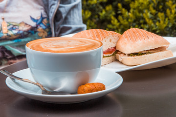 Coffee art and panini at outdoor cafe
