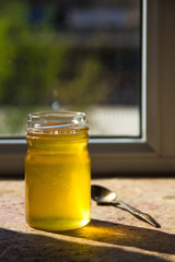 Organic pure honey in jar on window sill