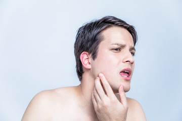 young man checking his facial skin. men's skincare concept.