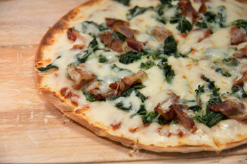 Pizza with bacon on a wooden