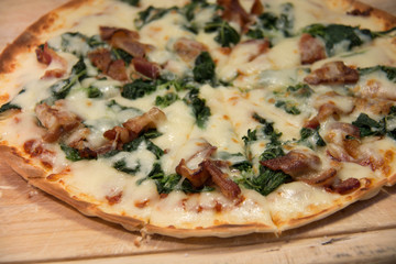 Pizza with bacon on a wooden