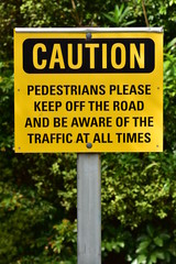 Warning sign for pedestrians in black block letters on bright yellow background.
