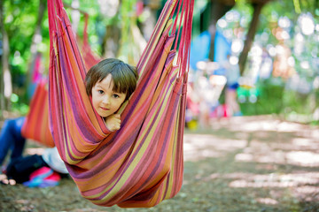 Cheerful child playing and lying inside the hammock