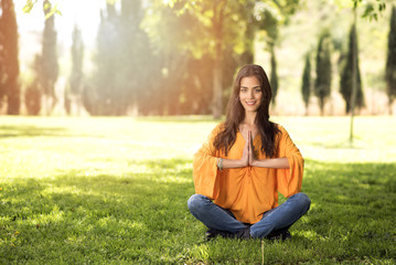 Fototapeta premium beautiful girl doing yoga exercises in a park