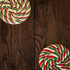 Bright lollipop on a stick against on a wooden texture. Sweets on a stick. Colorful sugar lollipop on wooden table.