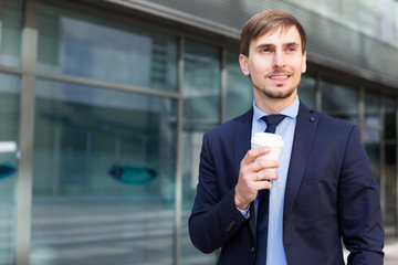 Naklejka na ściany i meble Businessman in suit with cup of coffee