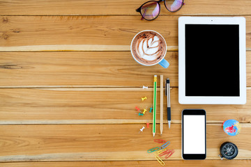 Office stuff with tablet computer,pen,smartphone,pencil and cup of coffee.Top view with copy space.Working desk table concept.