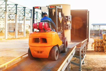 Forklift is putting cargo from warehouse to truck outdoors © Mayatnikstudio