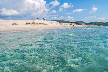 Fototapeta premium Porto Pino - large sandy beach, clear sea and unique sand dunes on the island of Sardinia.