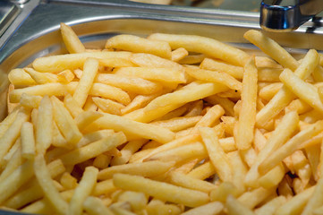 Golden fried potatoes fries on counter of restaurant fast food.