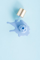 top view of spilled nail polish on blue surface