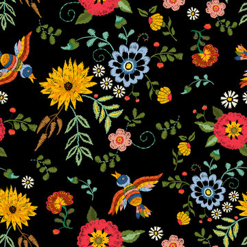 Embroidery ethnic seamless pattern with birds and fantasy flowers. Vector embroidered traditional floral design for fashion fabric.