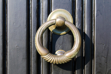 Brass door knocker on a black door