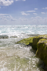 Seascape on a sunny summer day in the Caribbean sea shore. Blue sky with some clouds and white sand beach and turquoise water.