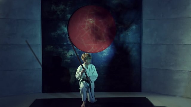 Boy Practicing Aikido Is Training With Bokken Sword