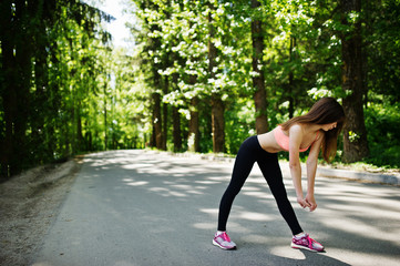 Fitness sport girl in sportswear doing stretching exercise in road at park, outdoor sports, urban style.