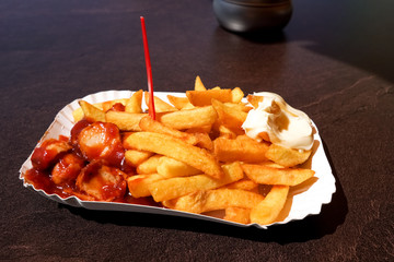 Pommes Mayo mit Currywurst auf Pappschale