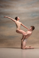 Fototapeta premium Couple of ballet dancers posing over gray background