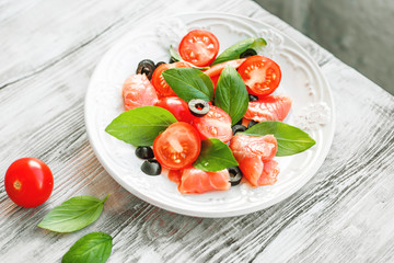 salad with salmon, basil, tomatoes and olives