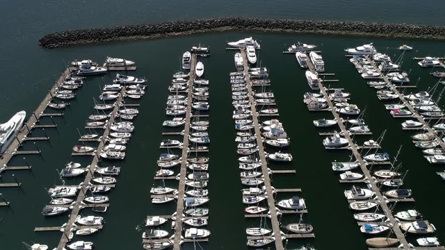 Aerial Drone Shot of Boating Season with Big Expensive Boats Docked at Ocean Marina on Sunny Day