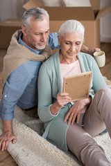 smiling senior husband and wife looking at photo frame together