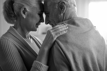 tender senior husband and wife embracing, black and white