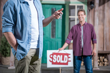 senior man buying new house and holding keys, selective focus