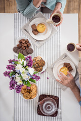 overhead view of couple drinking tea while having breakfast at home