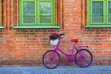 pink bike standing by the wall