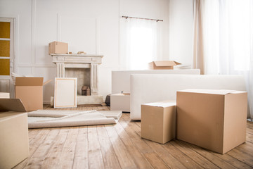 Picture frame and cardboard boxes in empty room, relocation concept