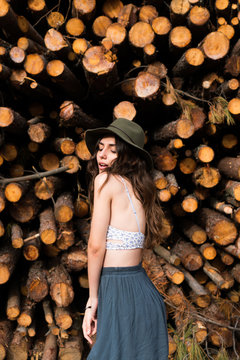 Sensual girl standing on background of logs