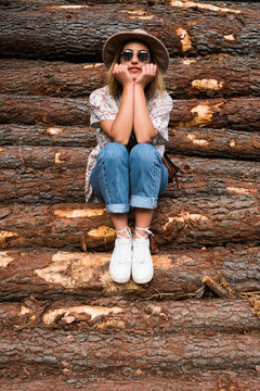 Trendy woman posing on wood logs