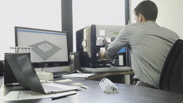 Man using desktop 3-D printer in office